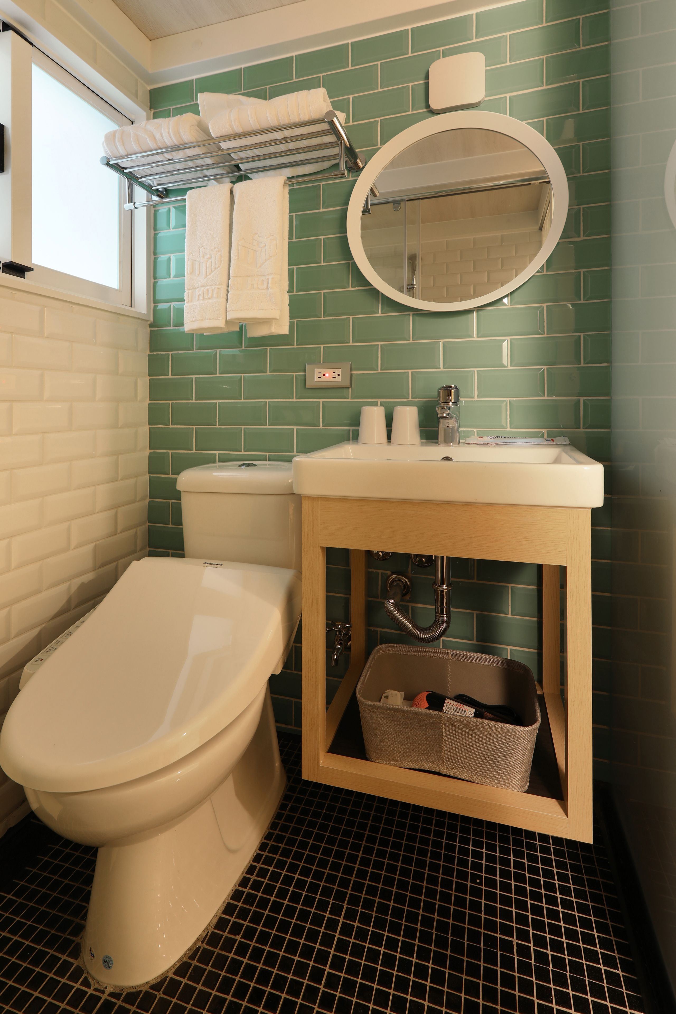 A bathroom with a toilet, sink, and mirror.