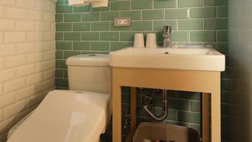 A bathroom with a toilet, sink, and mirror.