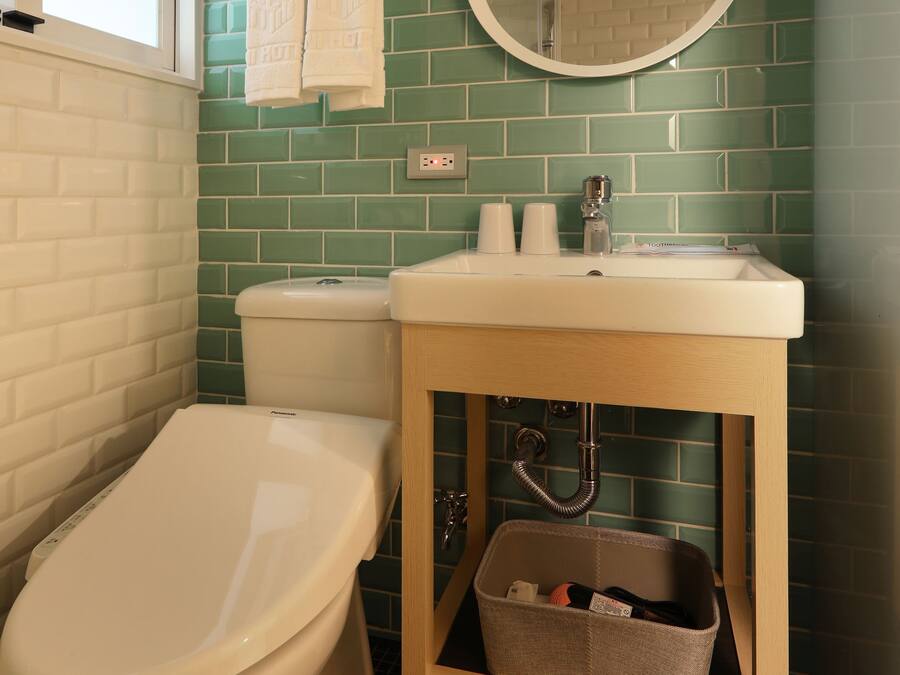 A bathroom with a toilet, sink, and mirror.