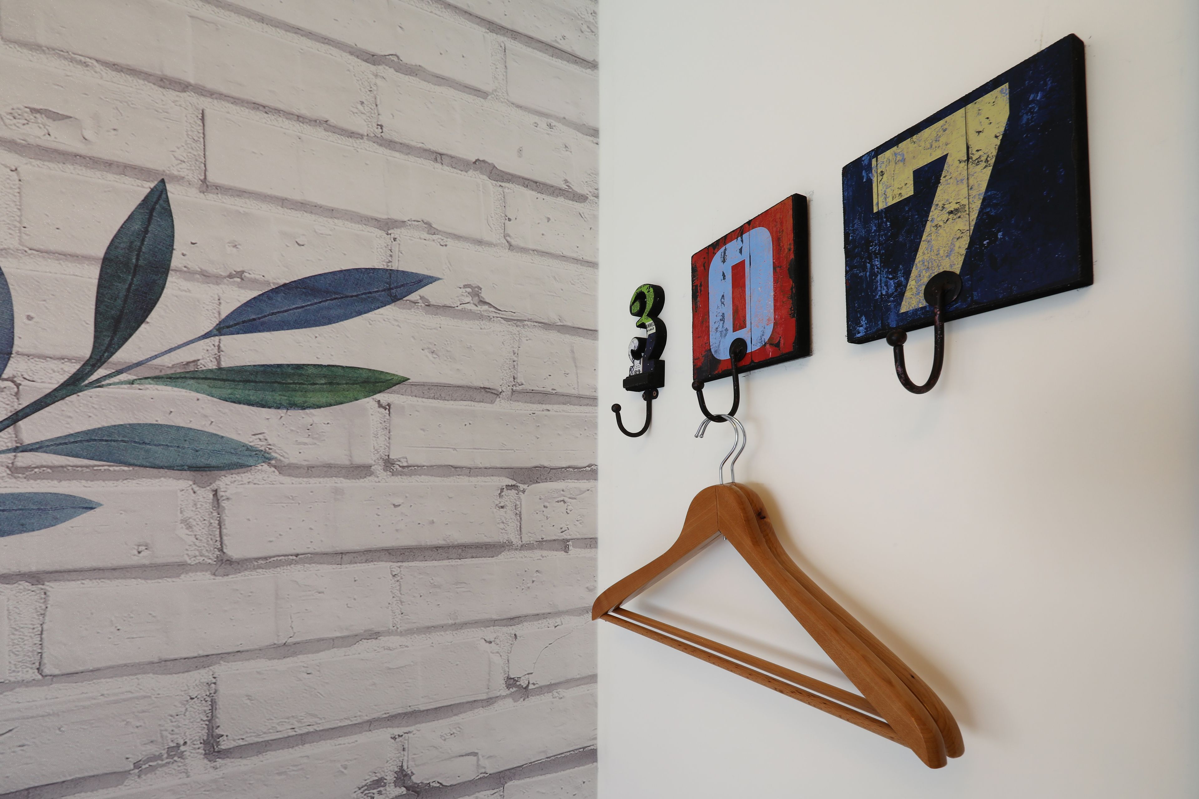 Una pared con diseño de ladrillo y un perchero de madera.
