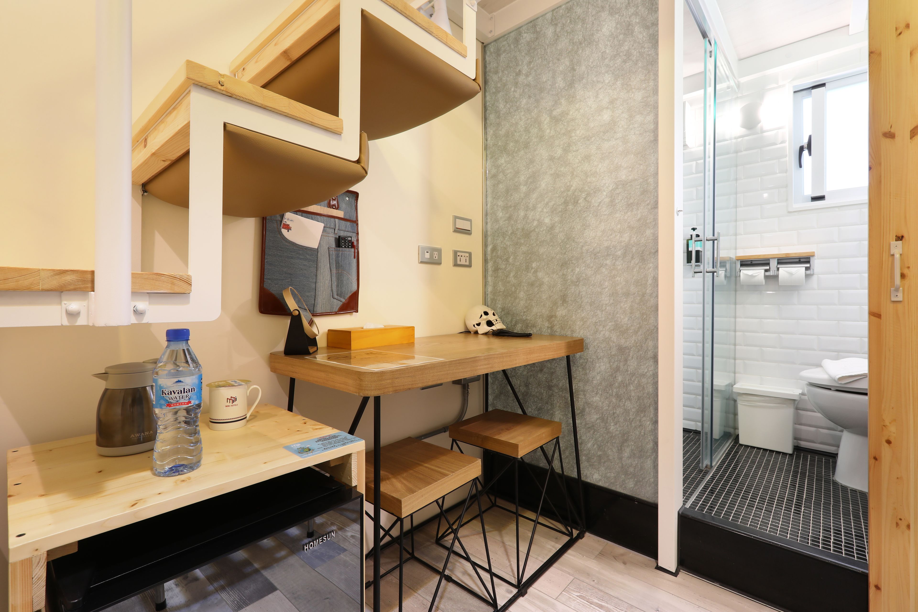 A compact bathroom with a wooden vanity, a shower area, and a small sink.