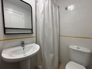 Ein Badezimmer mit Waschbecken, Toilette und Duschvorhang.