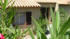 A house with a tiled roof and a window with a metal grill.