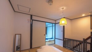 A hotel room with a bed, a mirror, a hanging lamp, and a view of the outside. - Guest house Connection Karasuma Gojo (Kyoto)