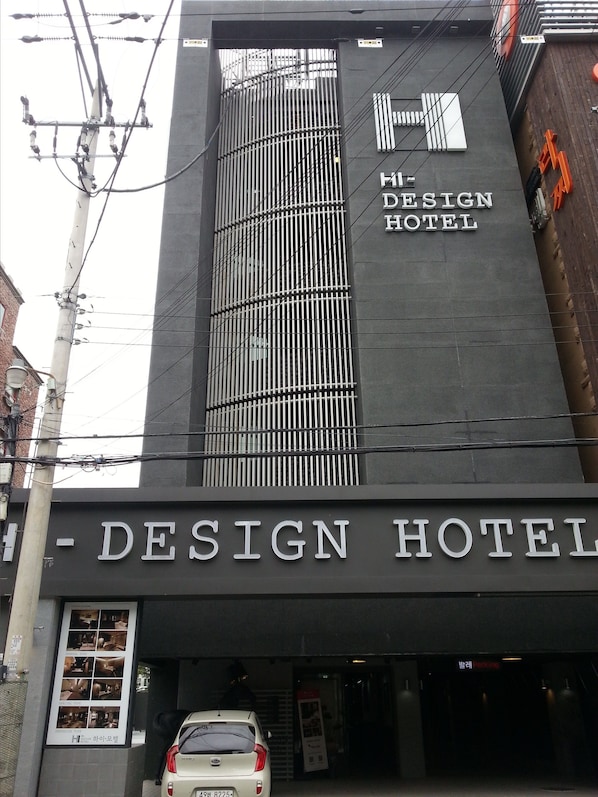 The exterior of the Hi-Design Hotel with a modern facade and a prominent vertical design element.