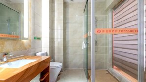 Ein modernes Badezimmer mit Marmorwaschtisch, einer Glasdusche und einer Toilette.