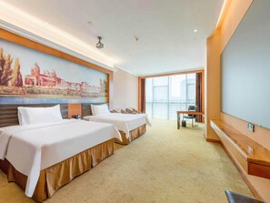 A hotel room with two beds, a large window, a painting on the wall, and a desk with a chair. - Vienna Hotel (Guangzhou)