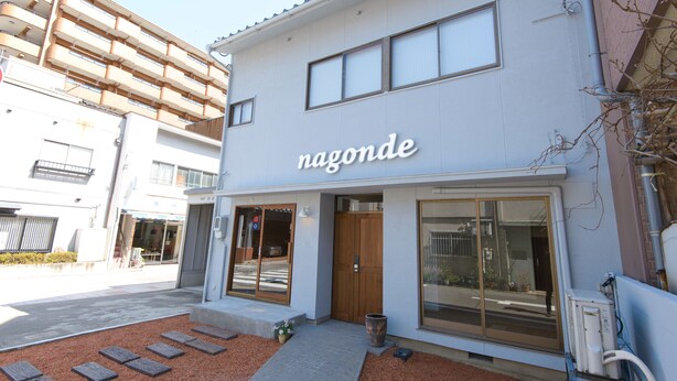 A modern building with a sign reading "nagonde" and a large glass door entrance. - Kanazawa guesthouse nagonde - Hostel (Kanazawa)