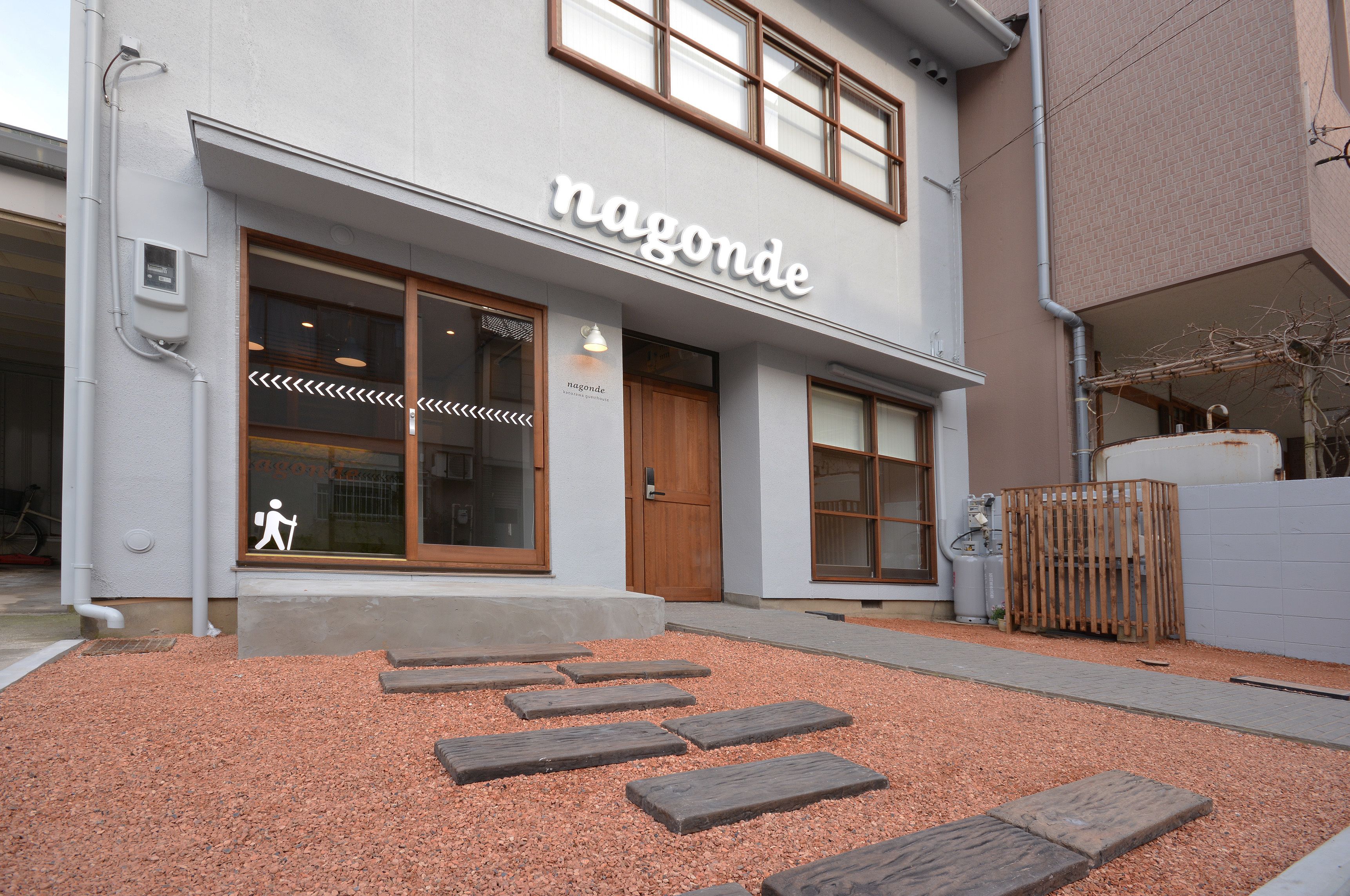 A building with a sign reading "nagonde" and a pedestrian pathway leading to the entrance.