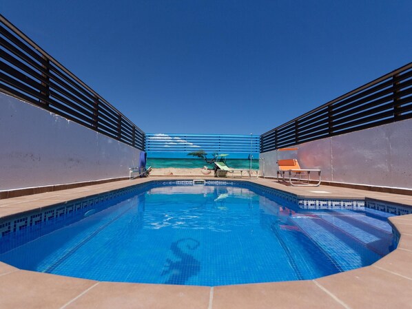 A swimming pool with a view of the ocean, surrounded by a deck with lounge chairs and a railing. - INNOUTHOMBEAUTIFUL FAMILY HOUSE WITH SWIMING-POOL, BBQ, WIFI AND AIR-11 SETEMBRE (L'AMETLLA DE MAR)