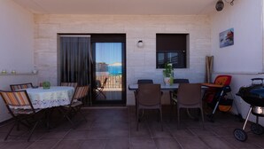 Un espace extérieur aménagé avec une table et des chaises, un barbecue et une vue sur la rue.