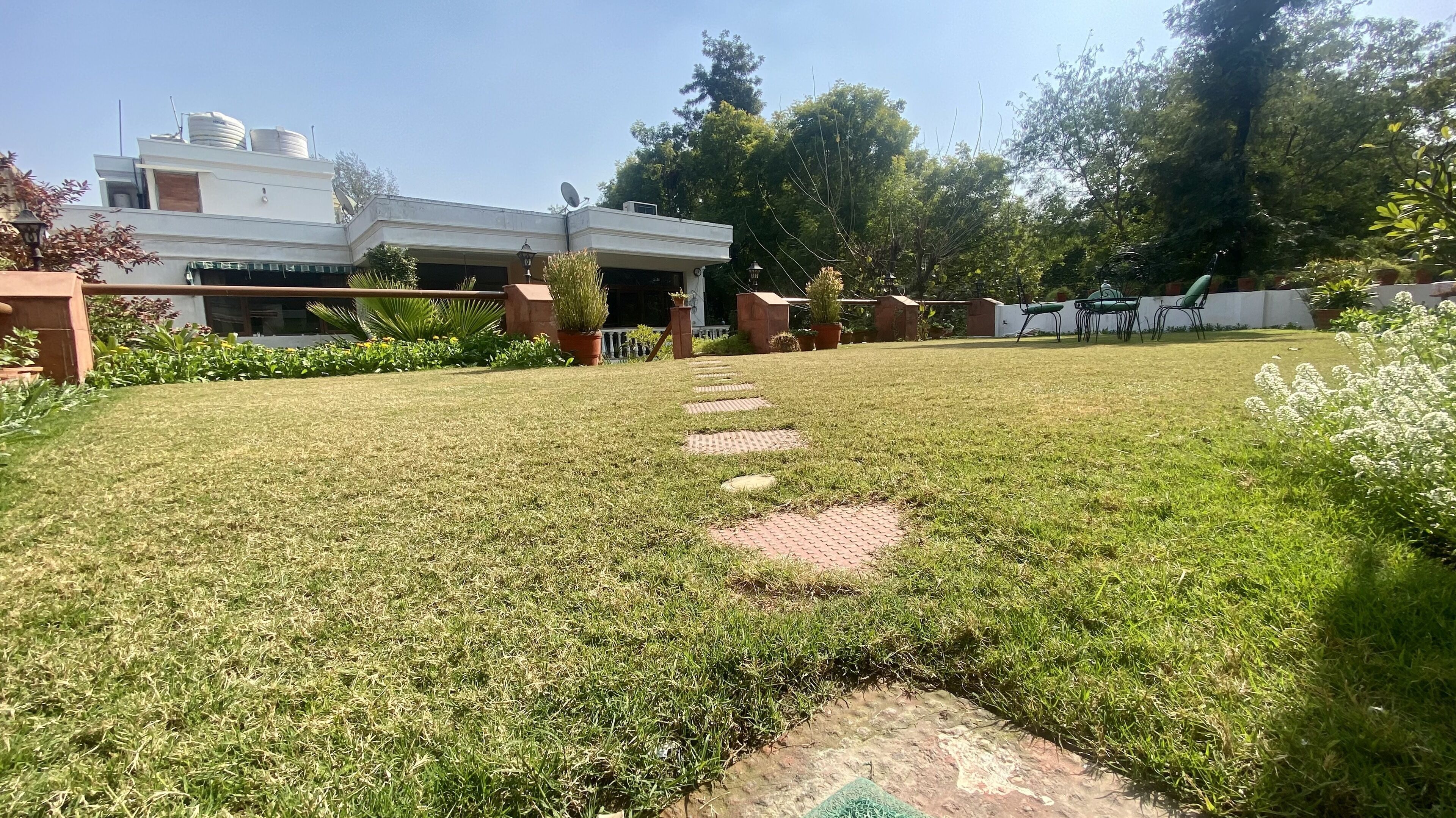 A well-maintained lawn with a paved pathway leading to a building.