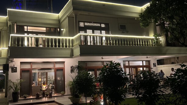Un immeuble de deux étages doté d’un balcon et d’une entrée bien éclairée.