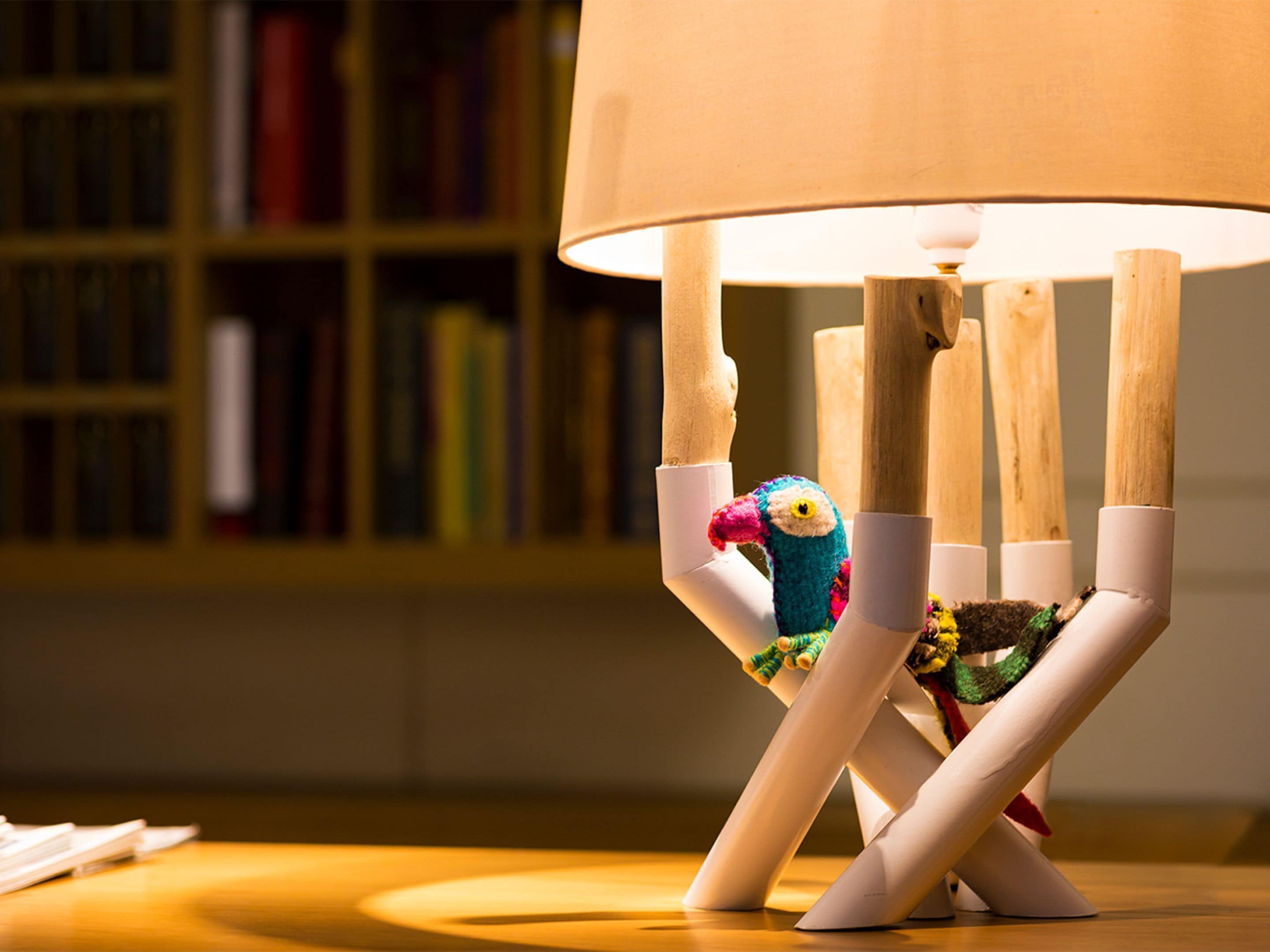Une lampe avec un pied en bois et un abat-jour blanc.