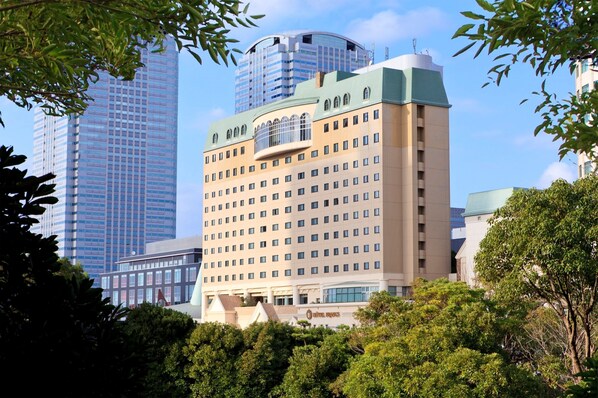 A hotel with a modern design, featuring a prominent curved glass facade and a flat roof. - Hotel Francs (Chiba)