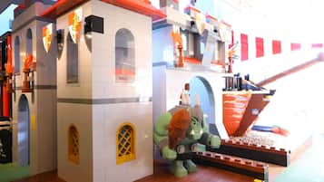 Un castillo LEGO con ventanas arqueadas y una estatua de dragón.