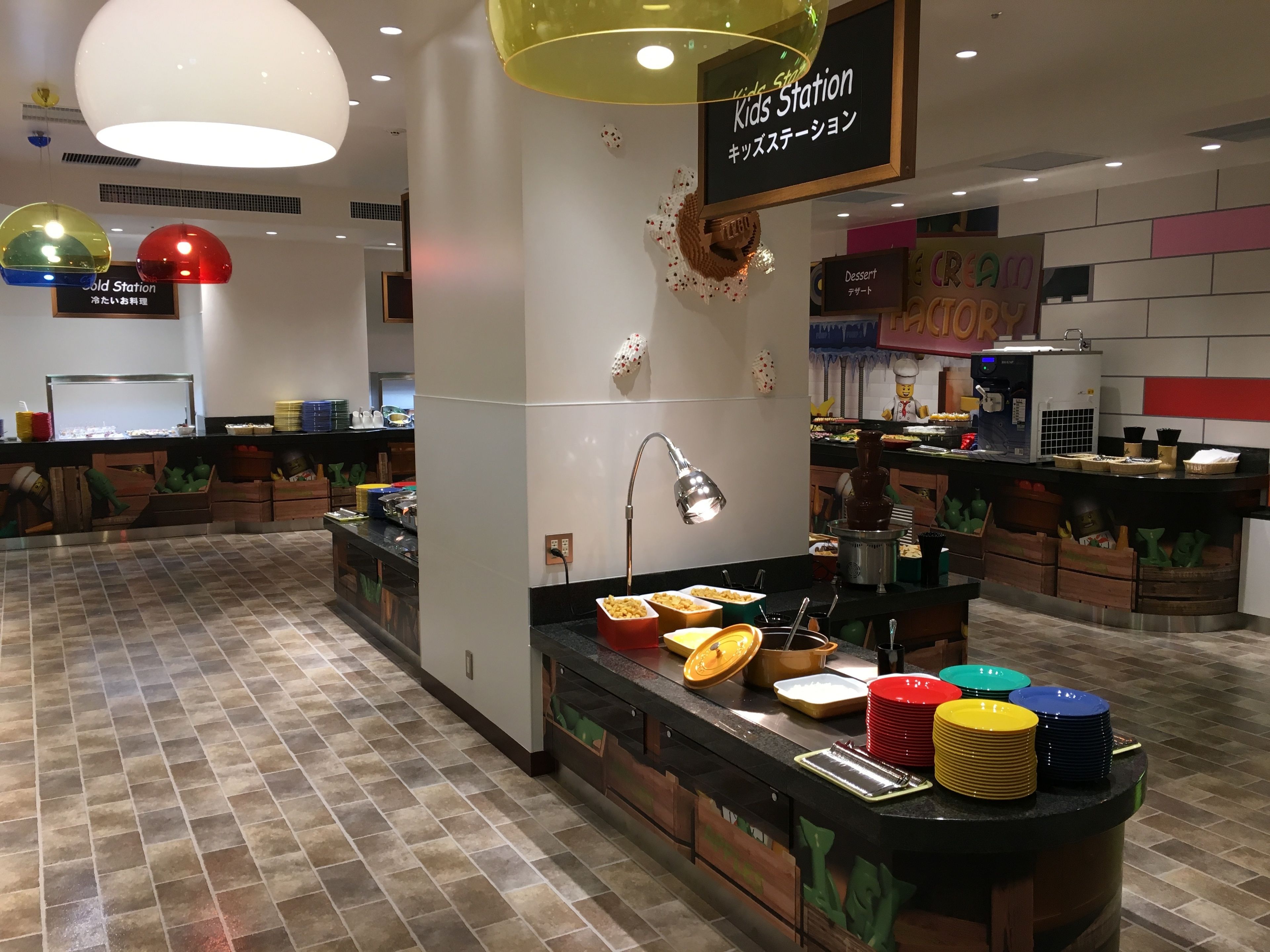 A children's dining area with a buffet setup, including a variety of food items and colorful plates.