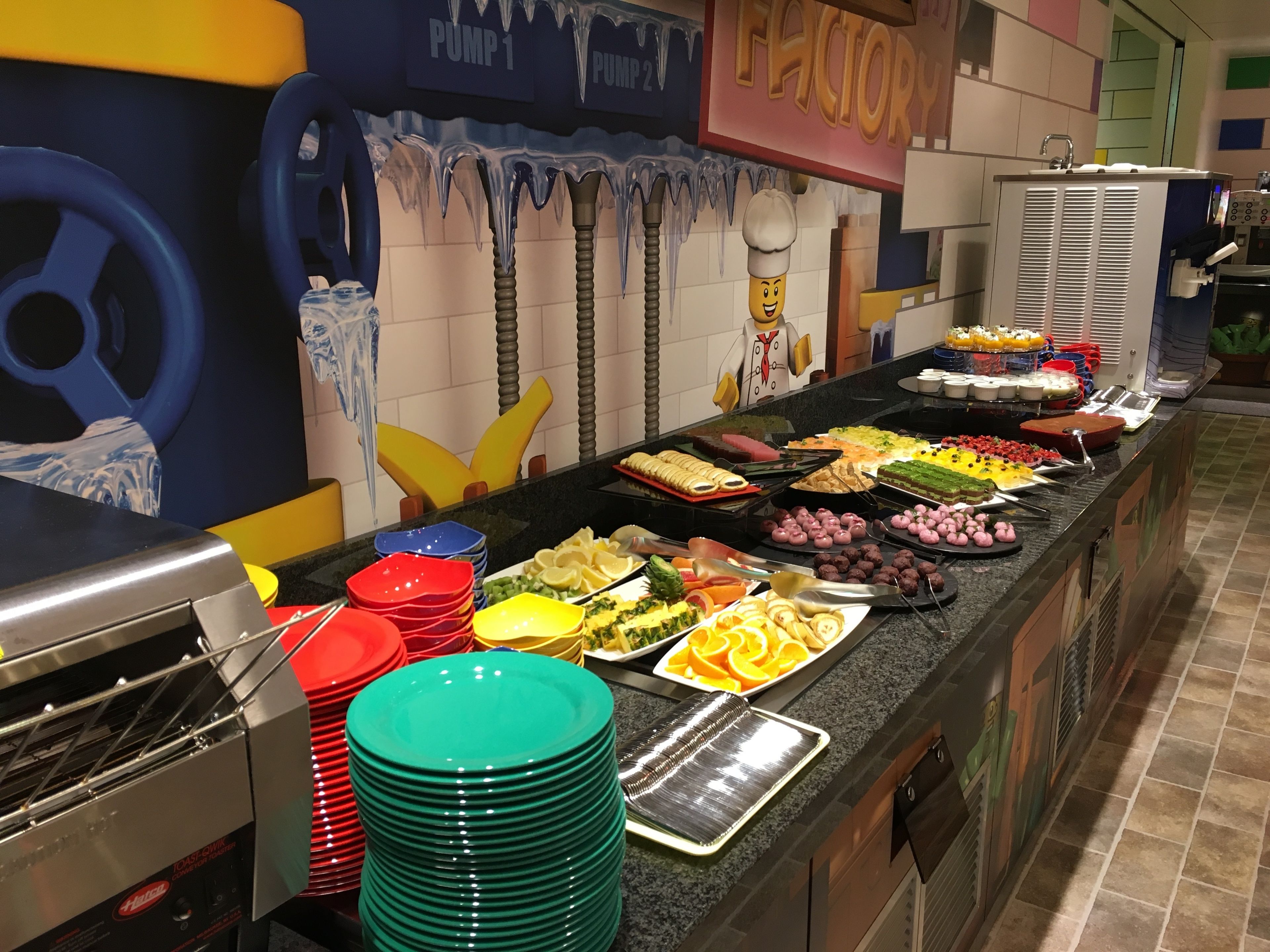 A buffet area with various food items and a large wall mural.