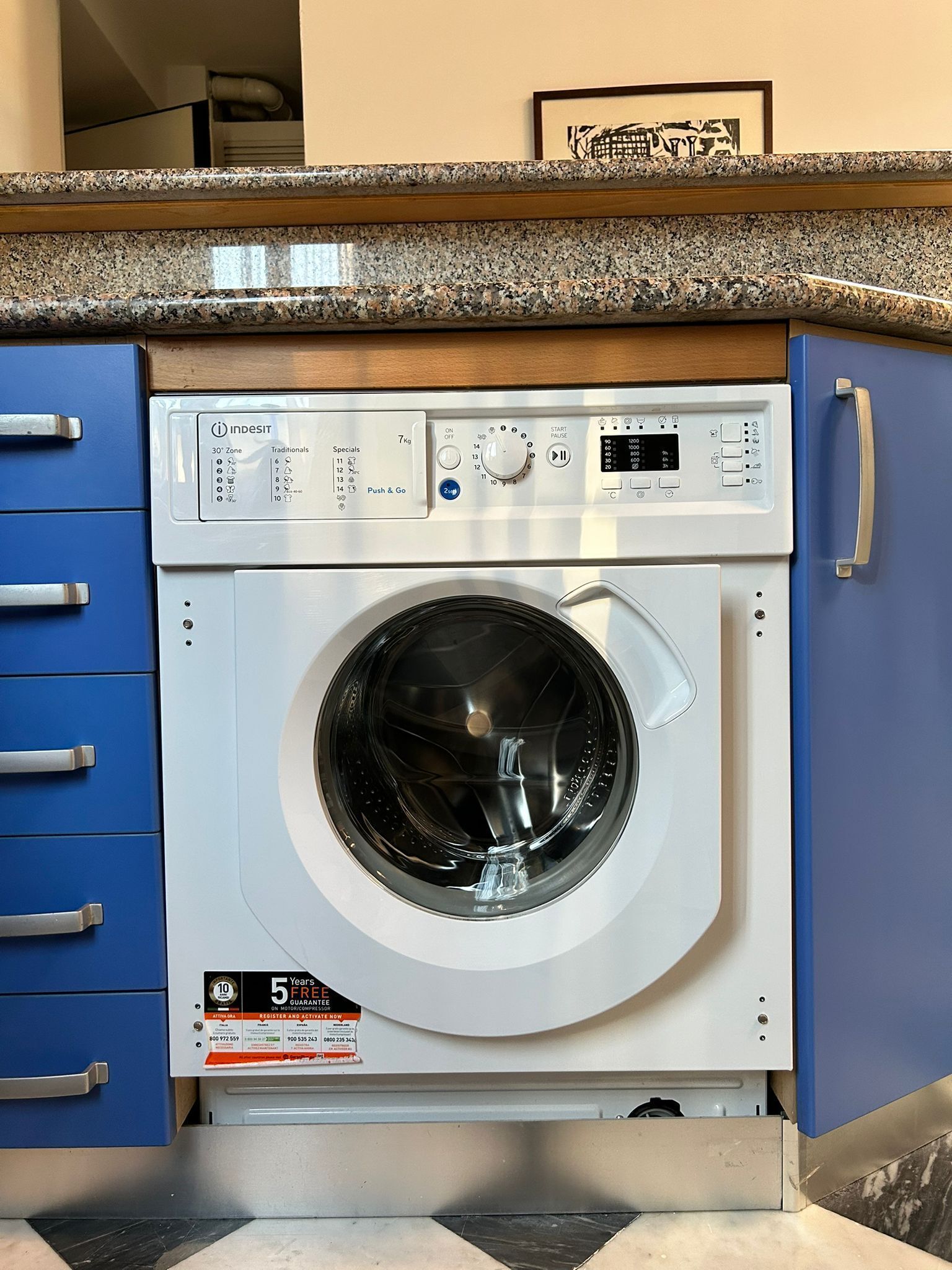 A front-loading washing machine with a digital control panel, a 30 kg capacity, and a 5-year warranty.