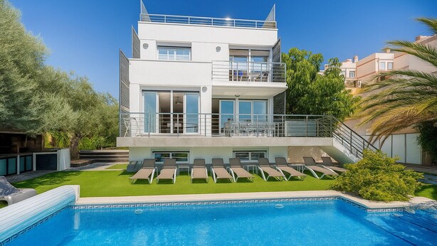 Un bâtiment moderne à deux étages doté d’une piscine, d’un espace extérieur aménagé et d’une pelouse bien entretenue.
