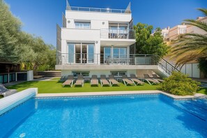 A modern two-story building with a swimming pool, outdoor seating, and a well-maintained lawn. - VILLA BENIDORM /SEA VIEWS, Last minute offer -50% (benidorm)