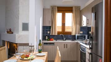 Een moderne keuken met houten kastjes, een roestvrijstalen koelkast, een magnetron en een spoelbak.