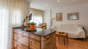 A compact living space with a kitchenette, a dining area, and a sofa. - INNOUTHOME PERFECT APARTMENT FOR HOLIDAYS, WIFI AND AIR_CATALUNYA APARTMENT (L'Ametlla de Mar)