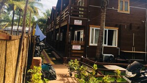 Un bâtiment en bois comprenant une réception, une piscine et une moto garée.