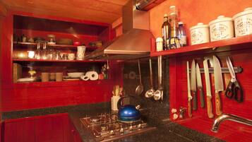 A kitchen with a gas stove, stainless steel sink, and wooden cabinets.