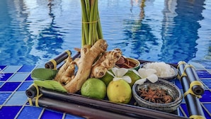 A poolside table with a variety of items including ginger, lime, and spices. - Xavia Hotel (Nha Trang)