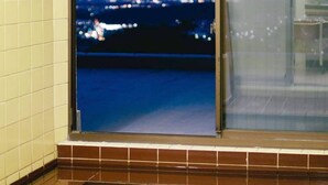 A view through a window with a tiled floor and a reflection of lights in the window. - Shiroyama inn (Ikoma)