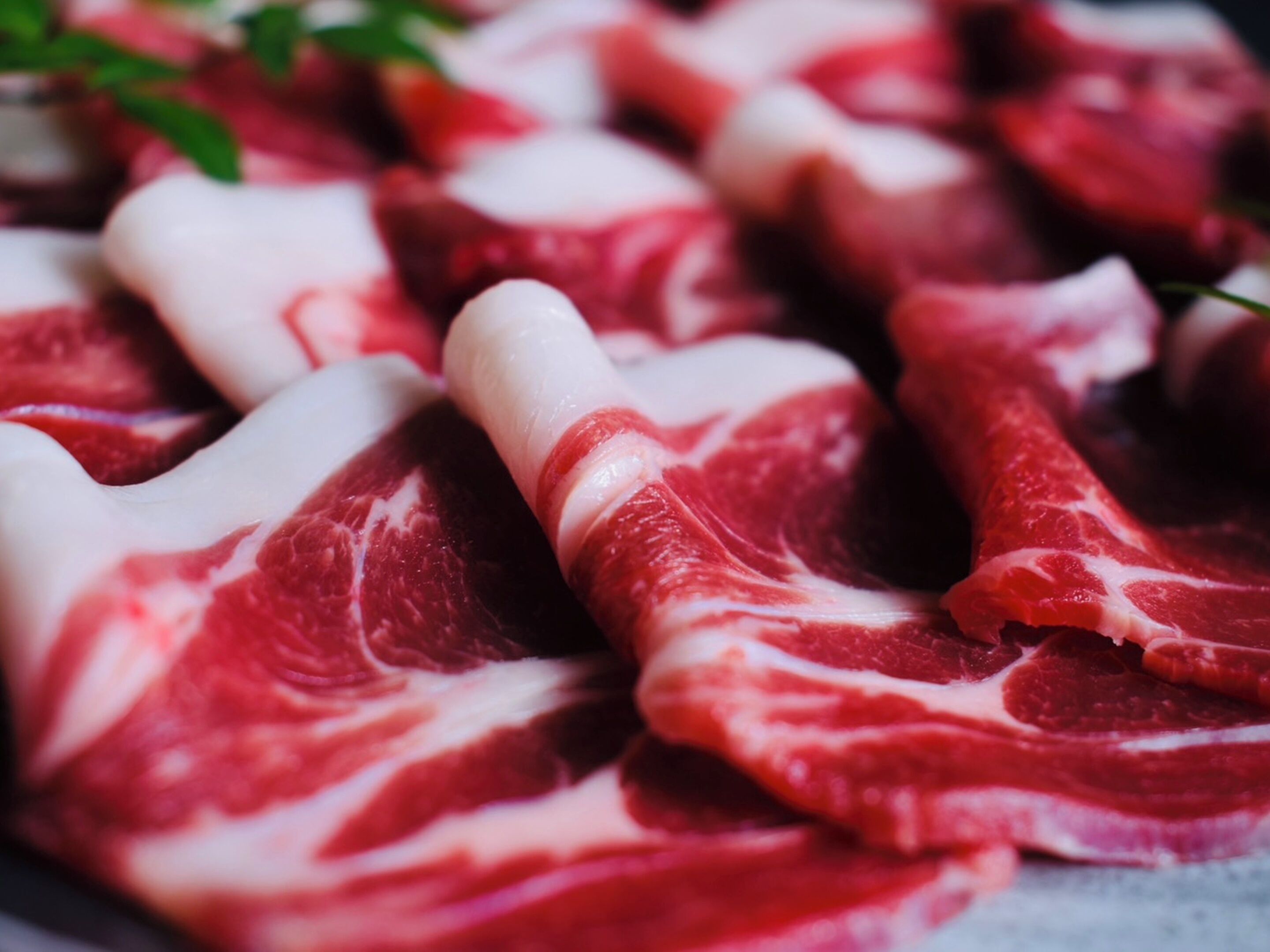 Viande crue présentant un persillage visible, probablement destinée à être utilisée en cuisine.