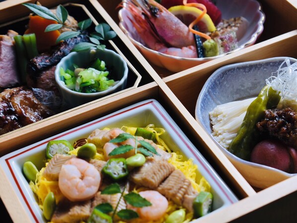 A variety of dishes in separate compartments, including seafood, vegetables, and rice.