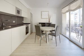 A modern kitchen with a dining area, large windows, and a view of the city.