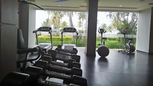 Een sportschool met loopbanden, gewichten en een crosstrainer.