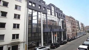 Un edificio moderno con ventanas amplias y un estacionamiento.