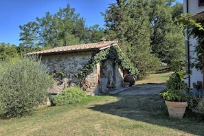 Surrounded by lush greenery, this charming cottage offers a peaceful retreat with a small porch and well-manicured lawn.