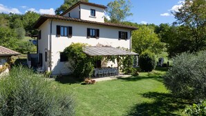 Una casa de dos pisos con un jardín delantero.
