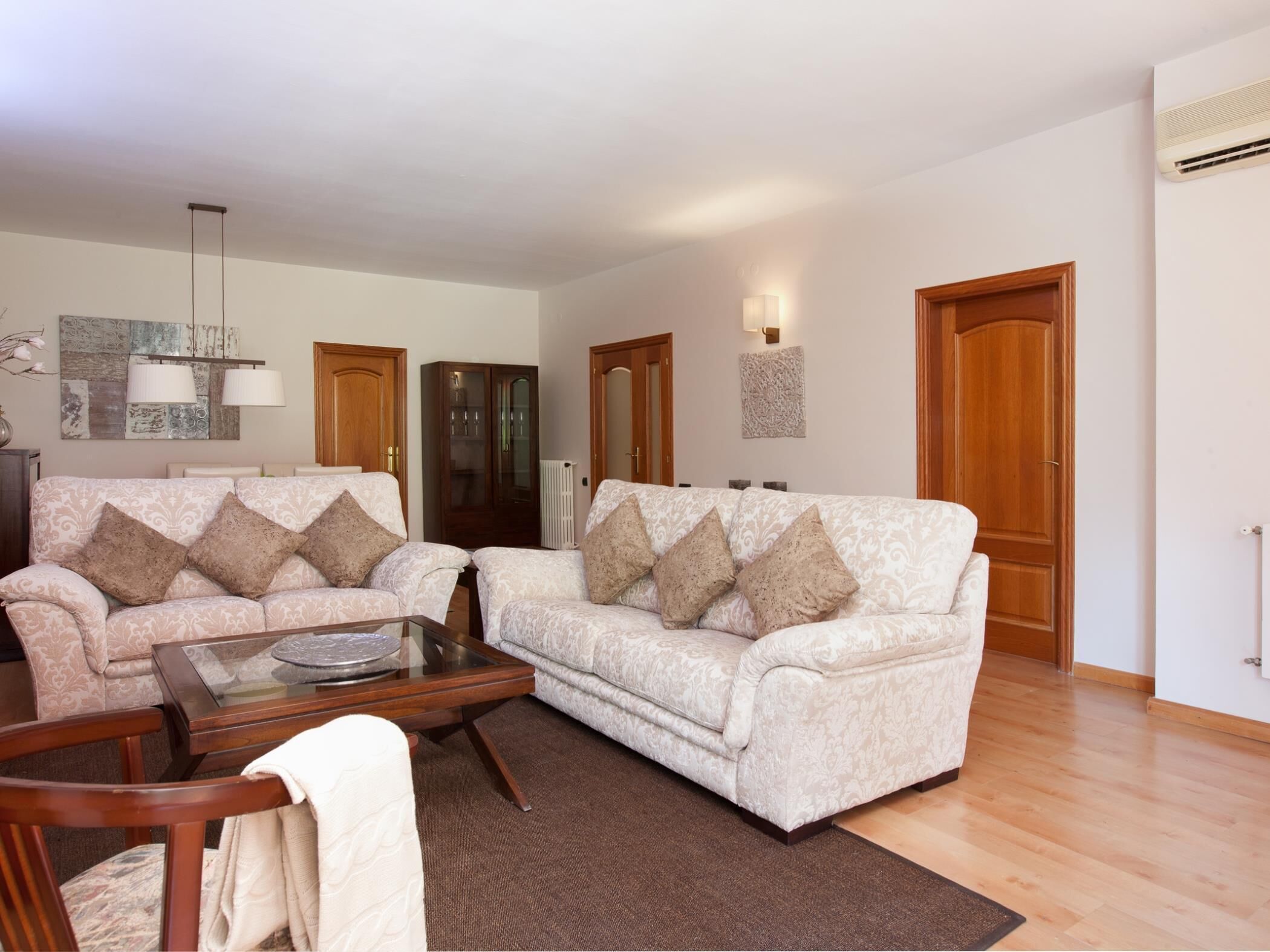 Ein Wohnzimmer mit zwei Sofas, einem Couchtisch und einem Schrank.