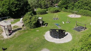 Un parque infantil con diversos juegos, incluyendo columpios, toboganes y estructuras para escalar.