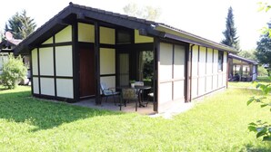 Una casa tradicional con entramado de madera y un porche cubierto, con una mesa y sillas.