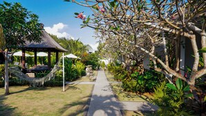 A pathway leading to a gazebo with a hammock and outdoor seating. - Uluwatu Jungle Villa (Pecatu)