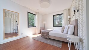 A modern bedroom with a large bed, a bedside table, a mirror, and a window with curtains. - Private Villa with swimming pool & barbecue (Funchal)