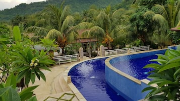 Una piscina al aire libre, sillones reclinables de piscina