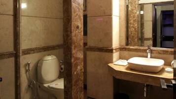 A bathroom with a toilet, sink, and mirror.