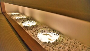 A pathway lined with pebbles and illuminated by recessed lighting. - Chika Miyabi (Kyoto)