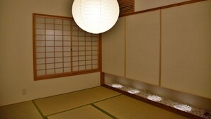 A traditional Japanese room with tatami flooring, a shoji screen, and a hanging paper lantern. - Chika Miyabi (Kyoto)