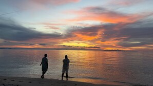 Two people standing on a beach, facing a sunset over the water. - Private Thai style villa with private  pool (Koh Samui)