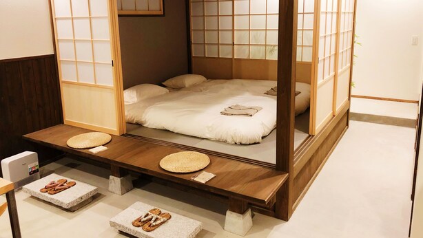 A traditional Japanese-style room with tatami flooring, a low platform bed with a wooden frame, and sliding shoji screens. - Chika Ichiyin (Kyoto)