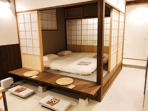 A traditional Japanese-style room with tatami flooring, a low platform bed with a wooden frame, and sliding shoji screens. - Chika Ichiyin (Kyoto)